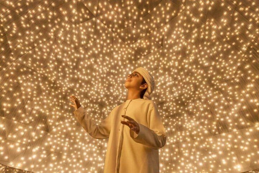 A person standing in front of a wall of twinkling lights. 1