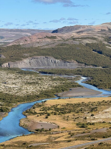 A river winding through a hilly landscape with sparse vegetation and rocky outcrops. 2