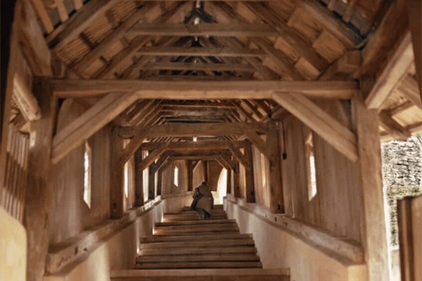 A wooden covered walkway with a person walking down the stairs. 5