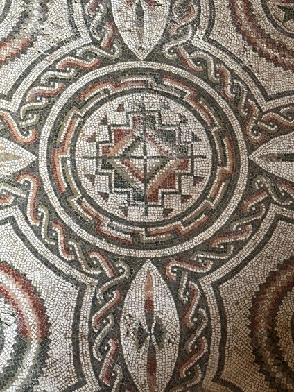 A detailed mosaic with geometric patterns and a central design. 3