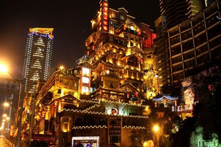 A brightly lit traditional building with ornate decorations and a modern skyscraper in the background. 2