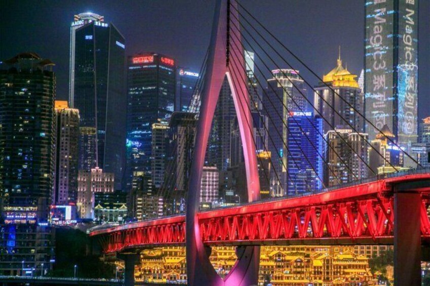 A nighttime cityscape with a prominent red bridge and illuminated skyscrapers. 1