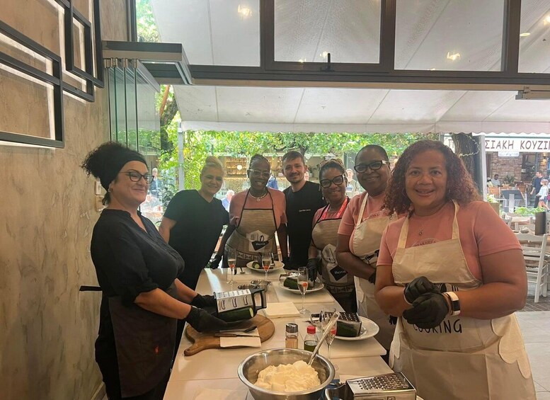 A group of people in aprons preparing food at an outdoor café. 4