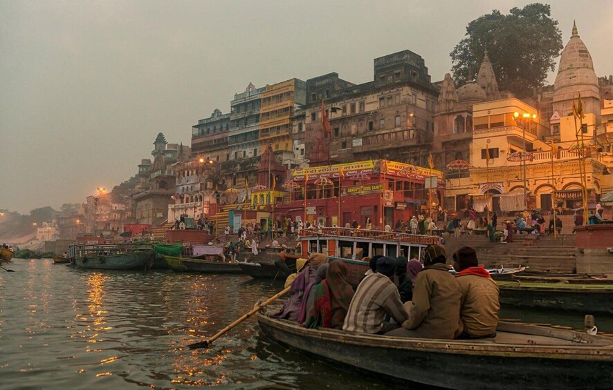A river with boats and people, a bridge, and buildings with colorful signs. 5