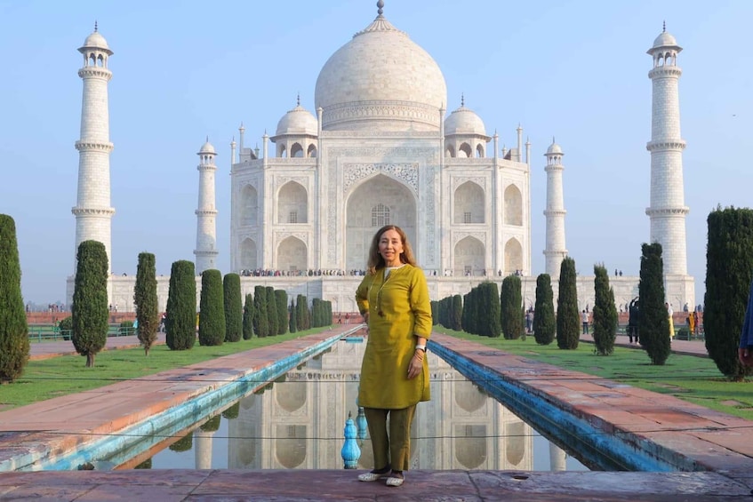 En person står foran Taj Mahal med sine fire minareter og centrale kuppel. 5