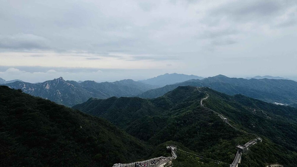A mountainous landscape with a winding road and a stone wall structure. 5