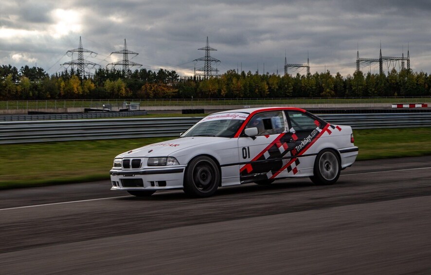 A white car with racing decals on a race track. 3
