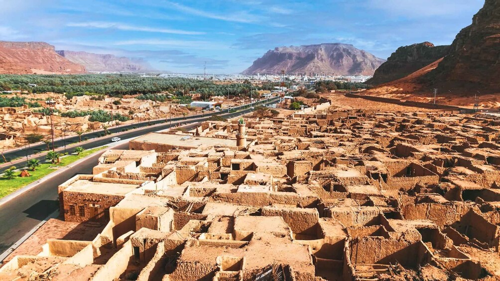 A vast array of traditional mud-brick structures in a desert landscape with mountains in the background. 2