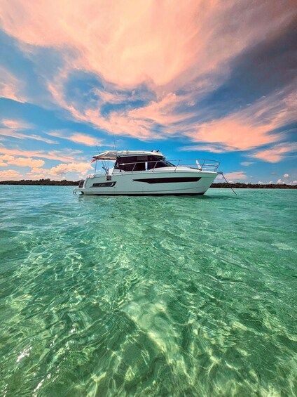 A white yacht on clear turquoise water with a pink and blue sky. 1