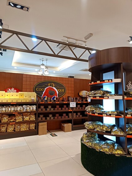 A store interior with shelves of packaged goods, a prominent sign reading 'COCOA UNIQUE,' and a ceiling with exposed beams and lighting fixtures. 5
