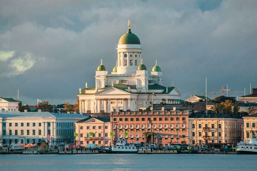 A large white building with a green dome and multiple smaller domes, surrounded by other historic buildings. 1