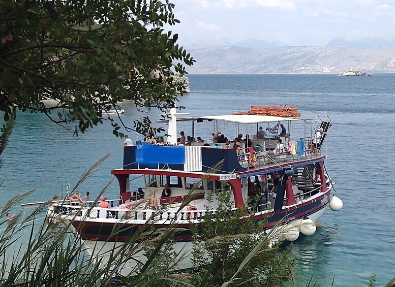 A boat with passengers, surrounded by water and mountains in the background. 1