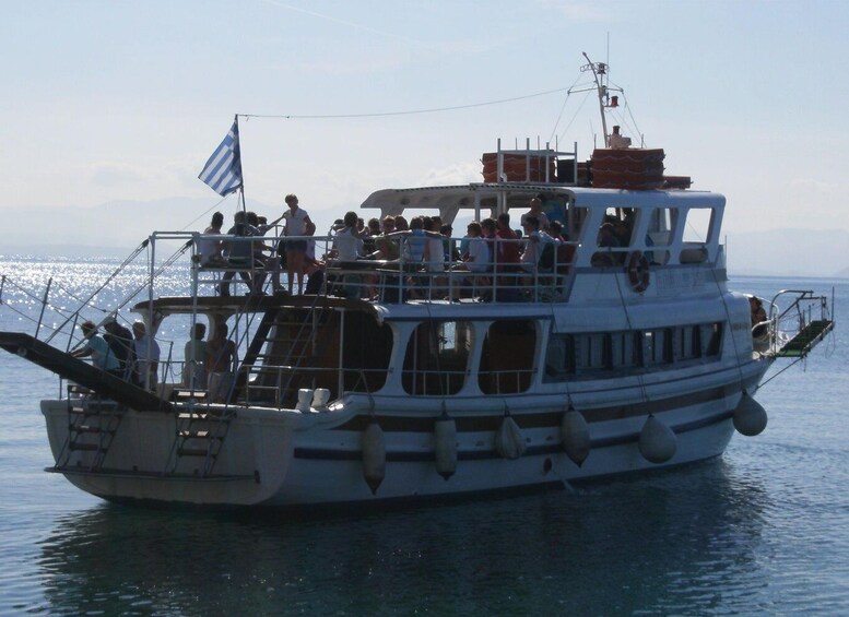 A boat with multiple decks and passengers, sailing on a body of water. 4