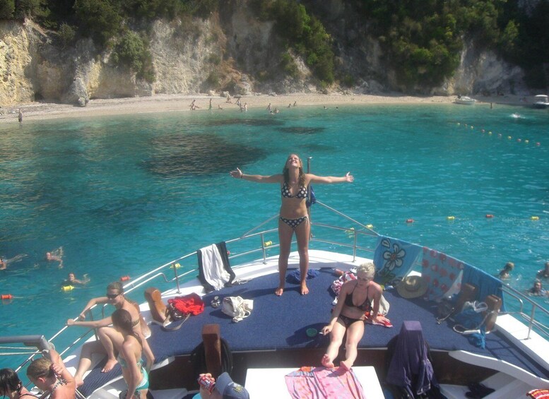A boat with people on deck and a beach in the background. 3