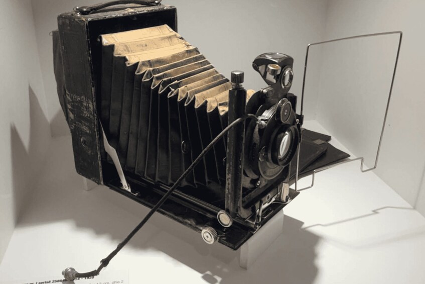 A vintage camera with a bellows mechanism, a lens, and a viewfinder. 2