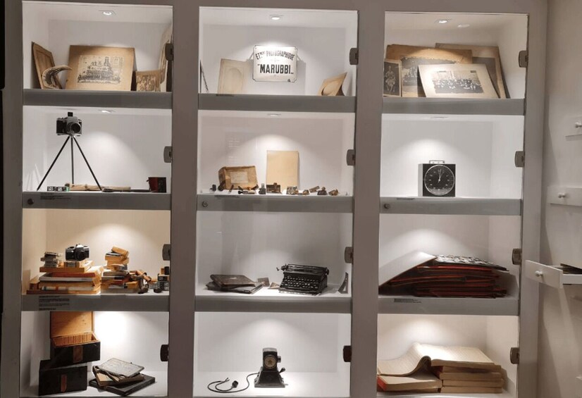 A display of vintage photography equipment and memorabilia in glass cases. 3