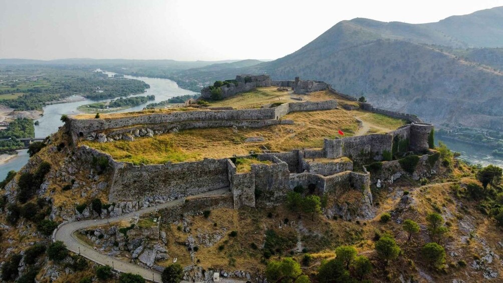 A historical stone fortification on a hill overlooking a river and valley. 1