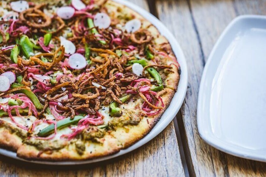 A pizza with toppings on a wooden table. 4