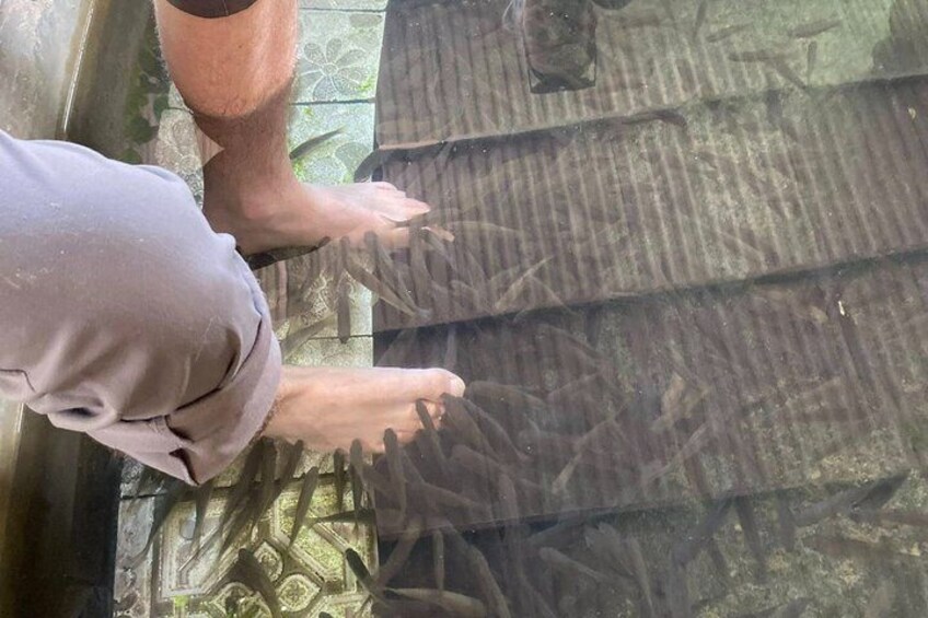 A person's feet touching a textured surface, possibly a floor or wall, with a pattern of lines and shapes. 2