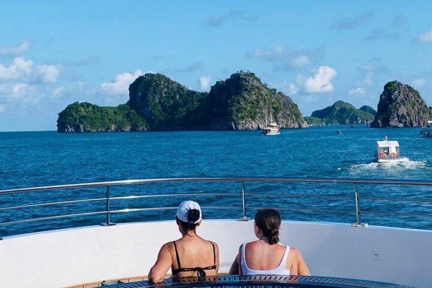 Two people on a boat with a view of green islands in the distance. 4