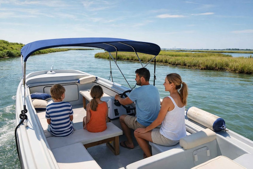 A family on a motorboat with a canopy, navigating a calm river surrounded by marshland. 3