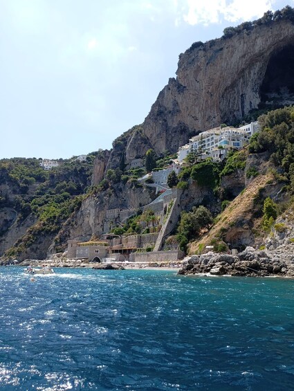 A coastal village with buildings perched on a cliff overlooking the sea. 1