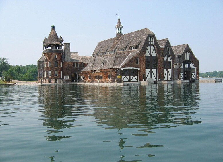 A historic building with a tower and a large water body in front. 1