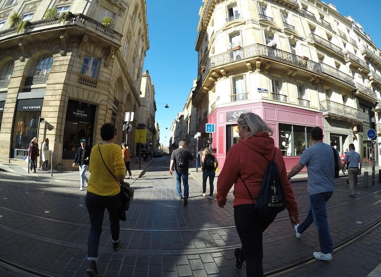 A busy urban street with pedestrians, vintage shops, and classic architecture. 4
