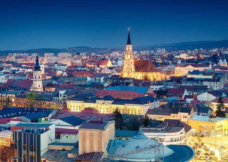 A cityscape at dusk with a prominent church tower, a round plaza, and a mix of historic and modern buildings. 4
