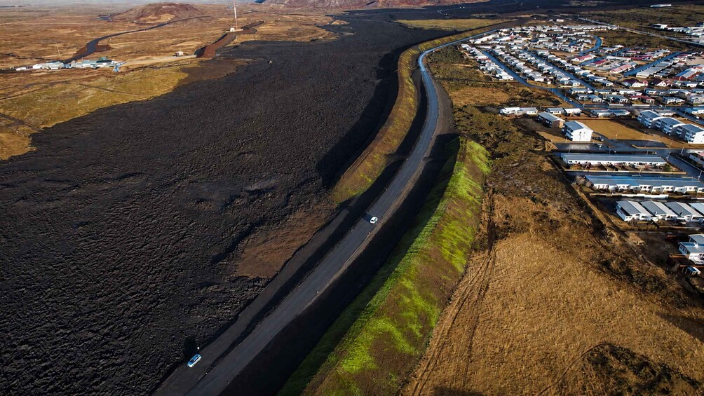 A highway curving through a barren landscape with a camp area on the right. 2