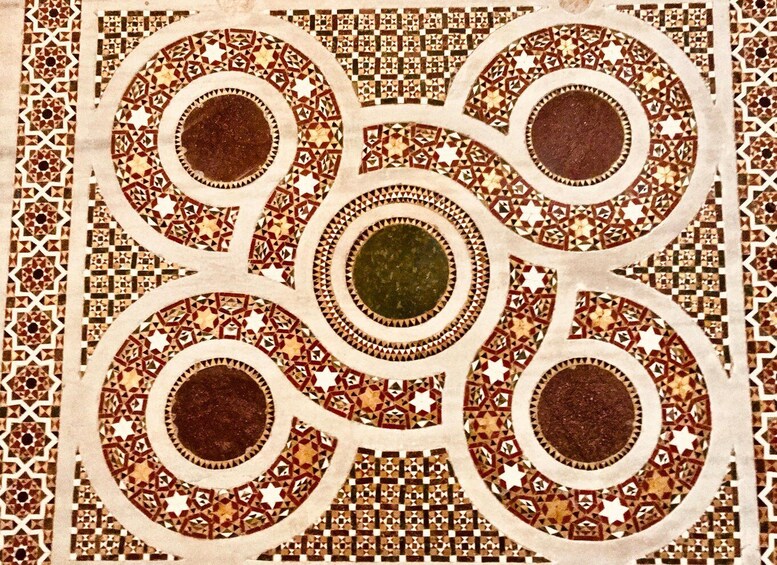 A detailed mosaic with geometric patterns and circular designs. 2
