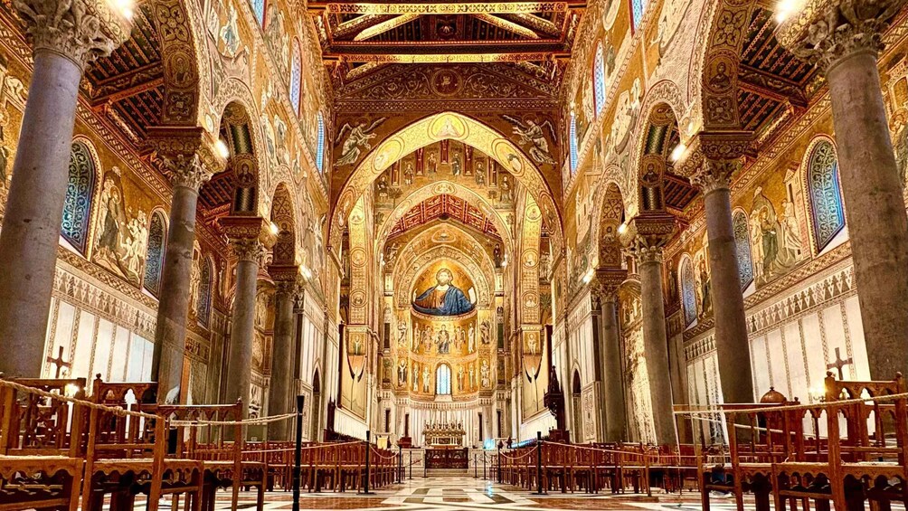 An ornate cathedral interior with high vaulted ceilings, detailed frescoes, and a central altar. 1
