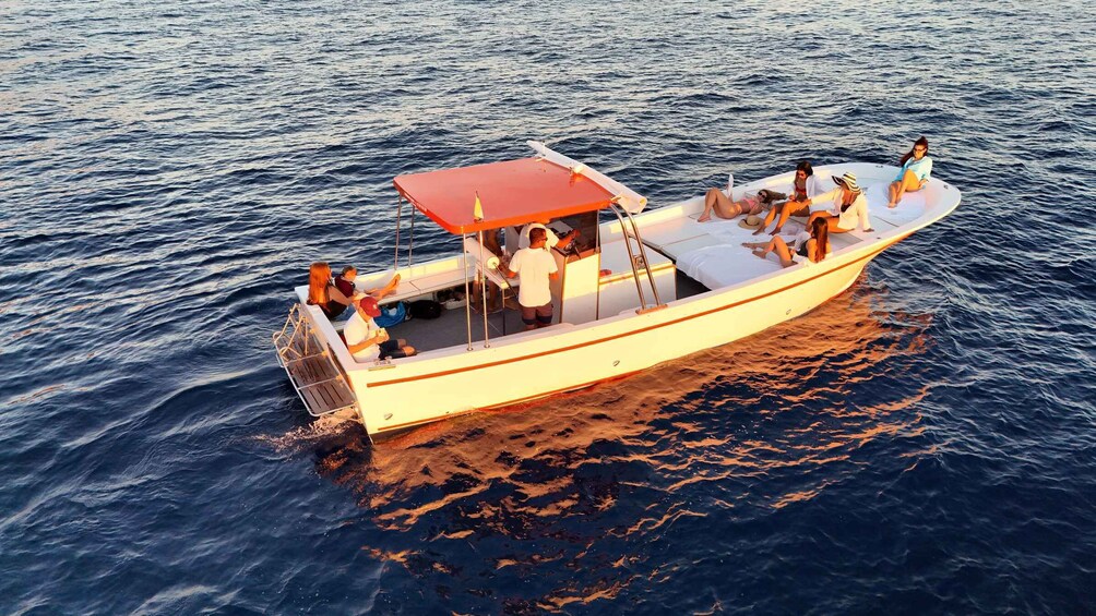 A small boat with people on board, floating on calm water. 1