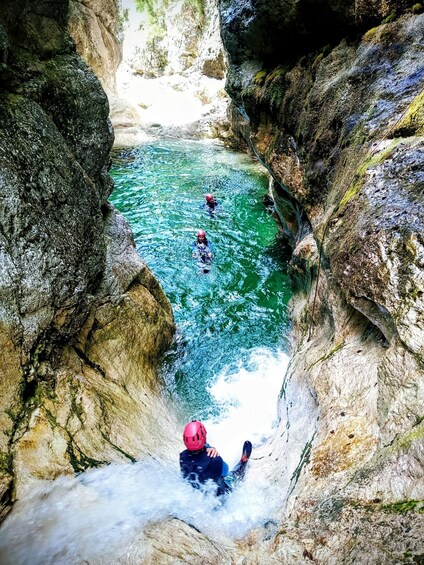 A river flowing through a rocky gorge with people engaged in water activities. 3