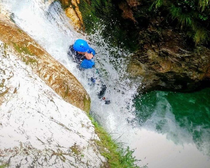 A person in blue gear navigating a whitewater rapids. 5