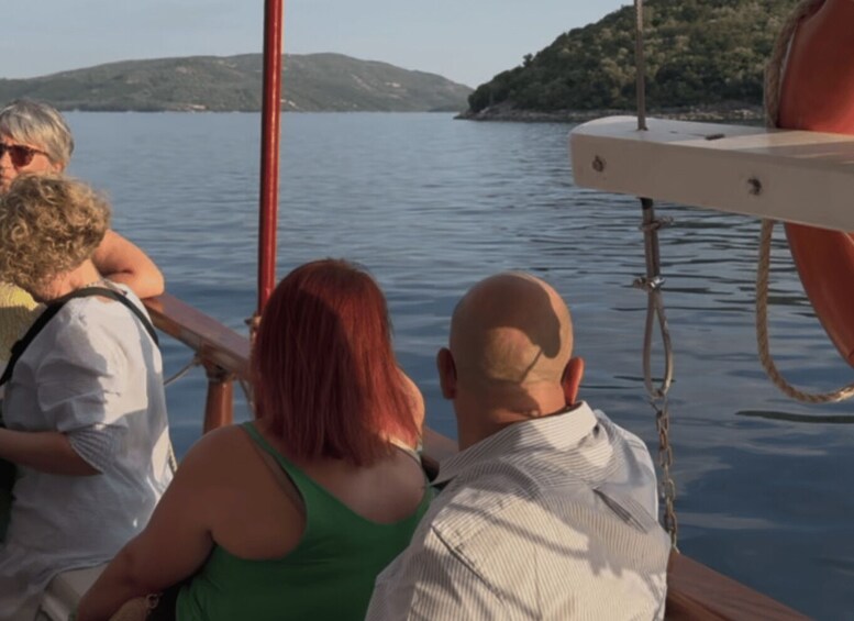 A group of people on a boat with a calm lake and hills in the background. 4
