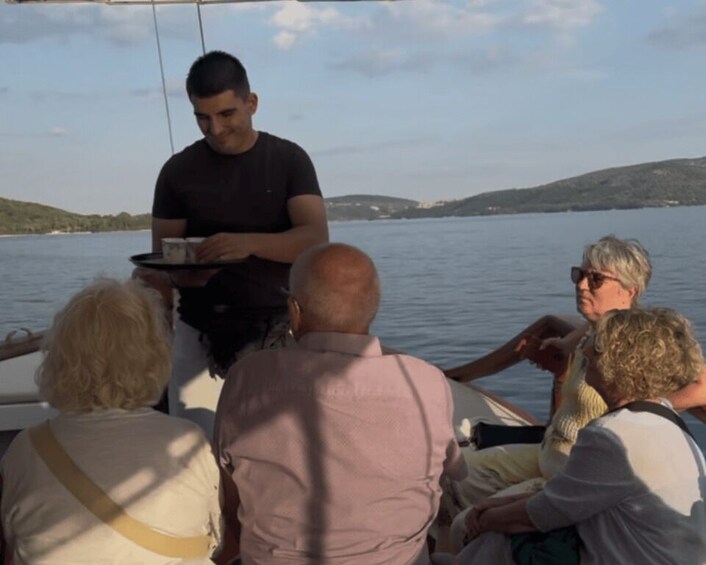 A group of people on a boat with a person serving drinks. 3