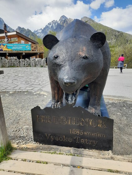 A bear statue with a sign reading 'HREBIENOK 1285 m n.n.m Vysoke Tatry.' 5