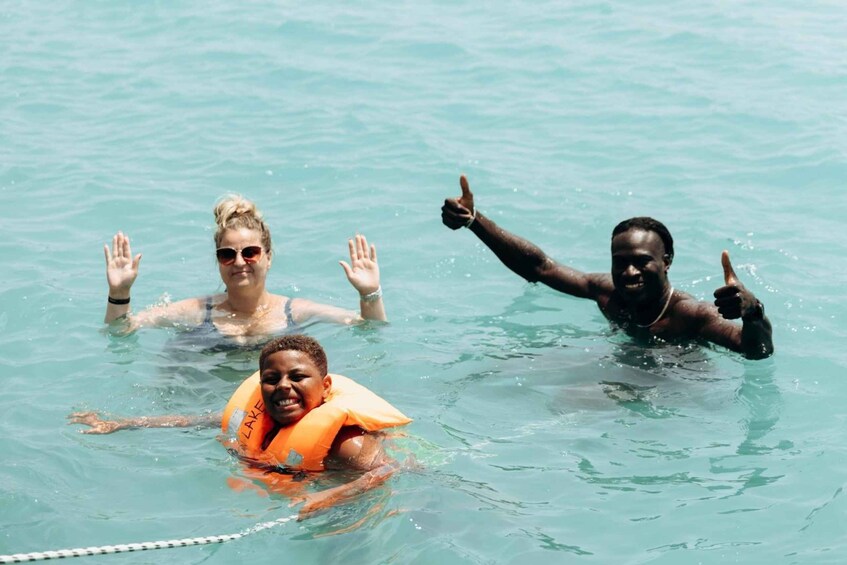 Three people in a swimming pool with clear water. 5