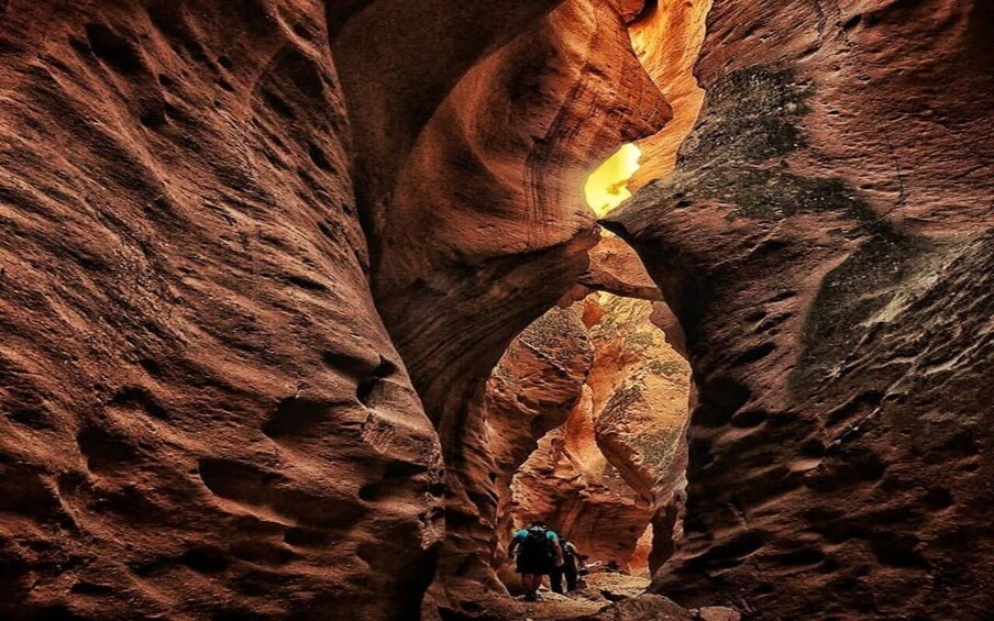 A narrow canyon with a person hiking through it. 2