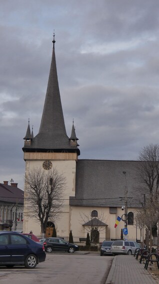 A church with a tall spire and a clock tower. 2