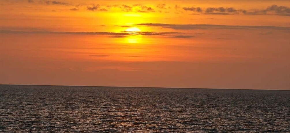 A sunset over a calm sea with a clear horizon. 2