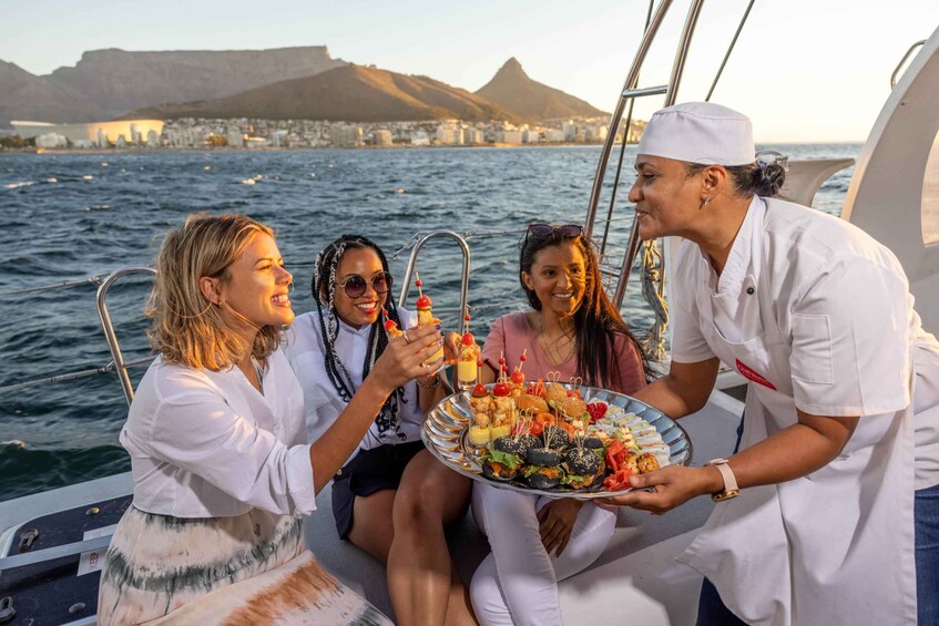 A group of people on a boat with a cityscape and mountains in the background. 2
