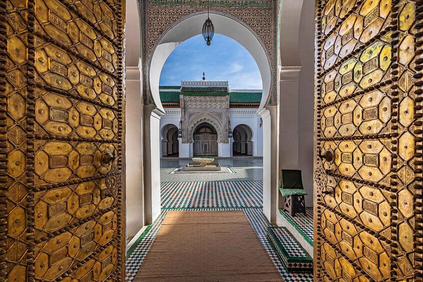A courtyard with a patterned floor, a central fountain, and a building with green-tiled roofs. 5