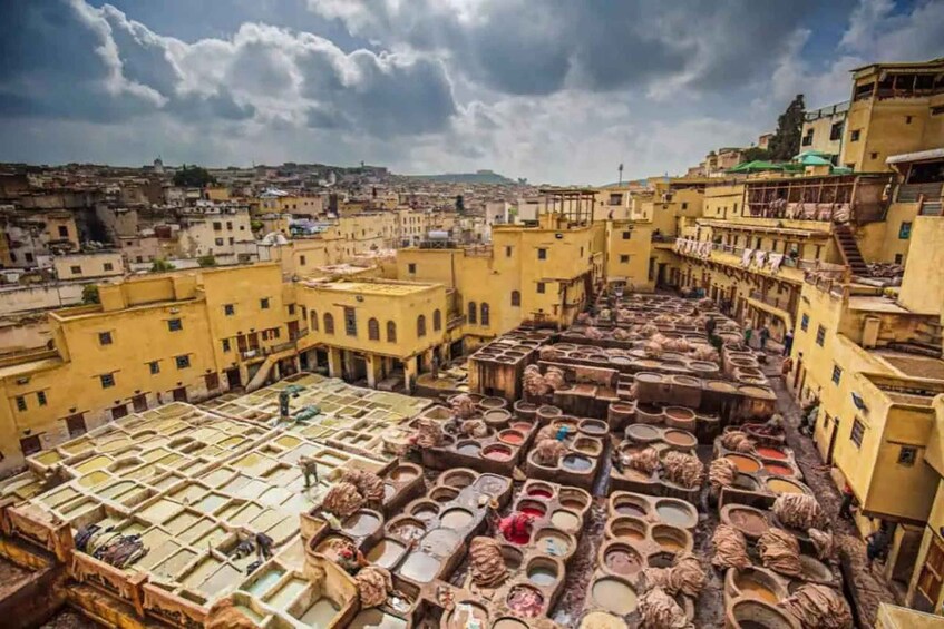 A traditional dyeing area with large vats and a cityscape in the background. 2