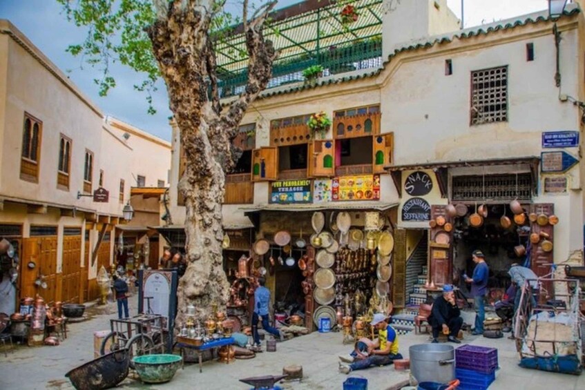 A bustling market street with shops selling pottery and metalware. 4
