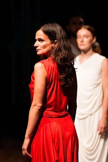 A person in a red dress and another in a white dress walking on a stage. 5