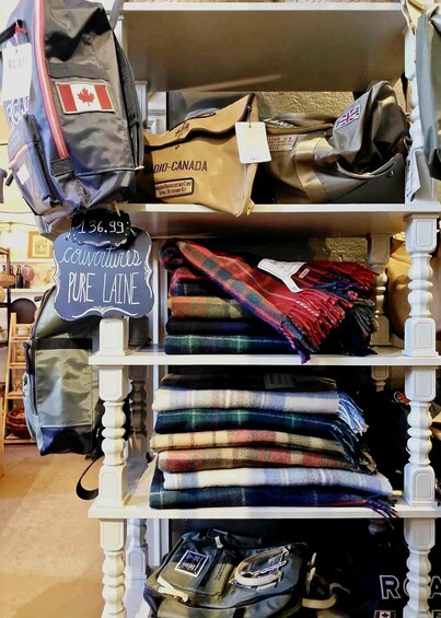 A clothing rack with plaid shirts and bags. 2