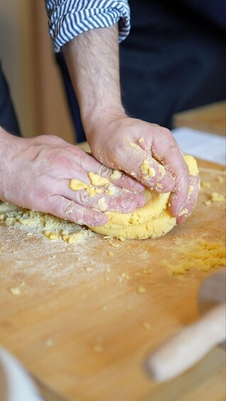 Hands kneading dough on a wooden surface. 2