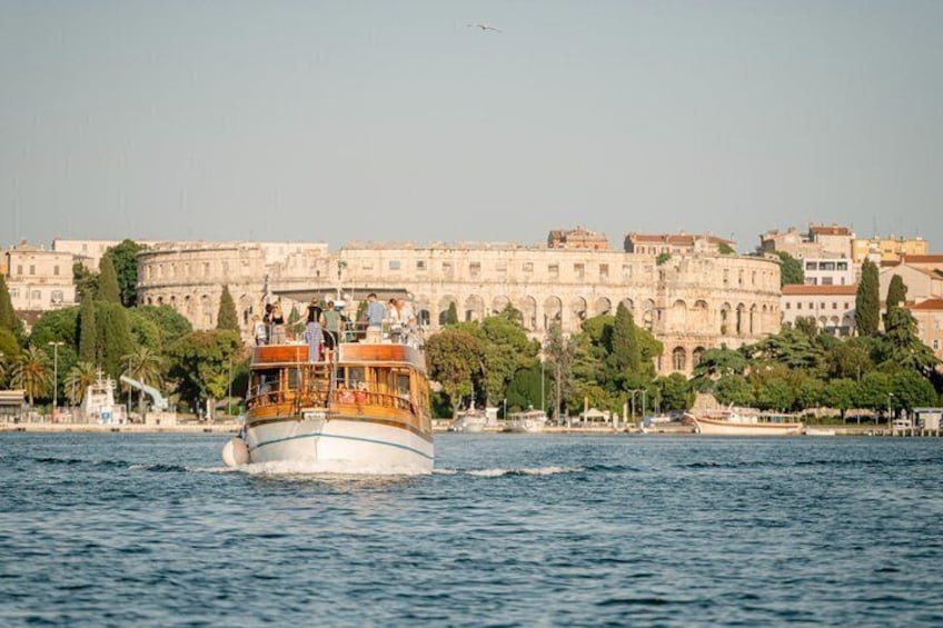 A boat with passengers, a historic building, and trees in the background. 1